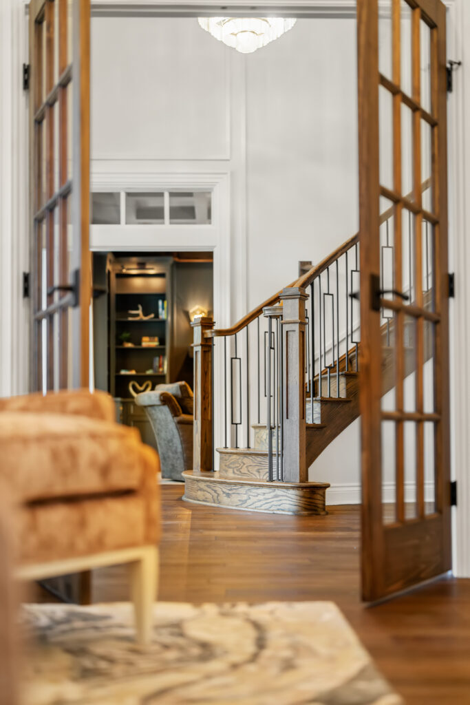 Renovated foyer with upgraded millwork, warm wood tones, and classic traditional detailing.
