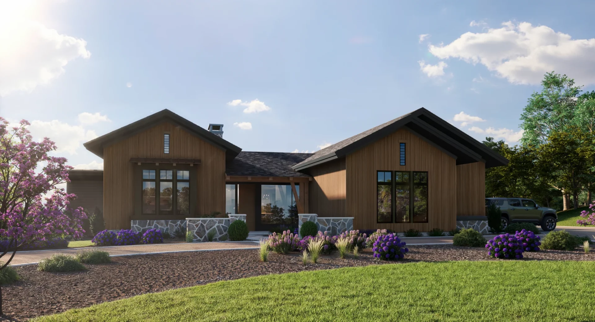 A modern mountain ranch-style home with a warm wood exterior, large windows, and stone accents. The house has a contemporary yet rustic aesthetic, surrounded by a landscaped front yard with blooming purple flowers, ornamental grasses, and a mix of greenery.
