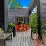 living-stone-–-wandering-oaks-modern-–-asheville-nc-–-custom-home-–-outdoor-deck-composite-orange-dining-string-lights-–-18