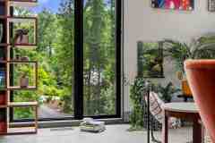 living-stone-–-wandering-oaks-modern-–-asheville-nc-–-custom-home-–-living-area-open-bookshelf-floor-to-ceiling-windows-–-05