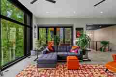 living-stone-–-wandering-oaks-modern-–-asheville-nc-–-custom-home-–-living-room-sectional-sofa-colorful-rug-forest-view-–-10