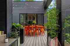 living-stone-–-wandering-oaks-modern-–-asheville-nc-–-custom-home-–-outdoor-deck-composite-orange-dining-string-lights-–-18