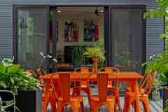 living-stone-–-wandering-oaks-modern-–-asheville-nc-–-custom-home-–-outdoor-deck-orange-dining-set-string-lights-–-19