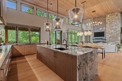 living-stone-–-waterfall-overlook-–-hendersonville-nc-–-custom-home-–-kitchen-island-open-living-room-stone-fireplace-–-04
